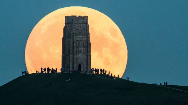 Luna gigante detrás de un edificio.