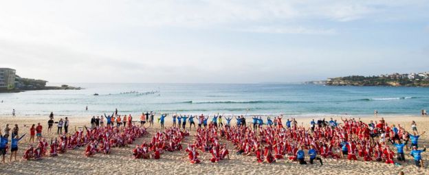 A pack of 320 surfing Santas embrace the Christmas spirit in Australia, breaking the Guinness World Record for the largest surf lesson