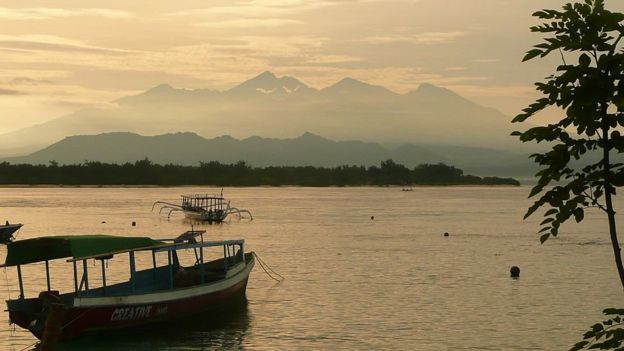 Photo taken on 1 May 2011 shows the sun rising over the Gili Islands, with the mountains of Lombok in the background.