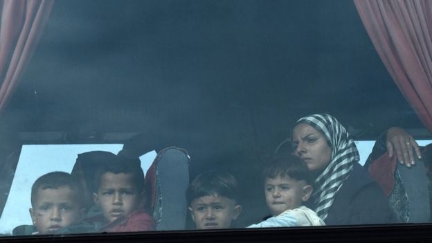 A woman and her children on a bus leaving Idomeni, on 24 May 2016