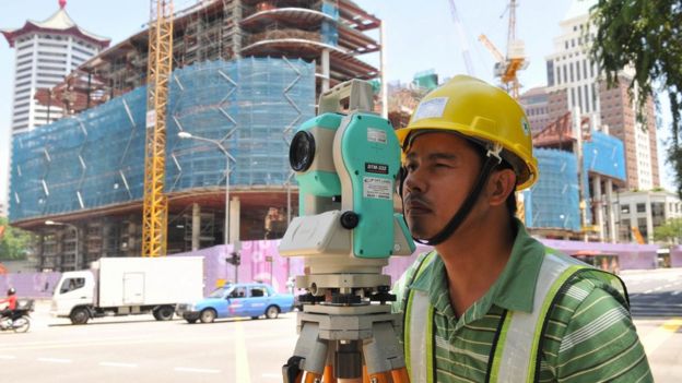 A migrant construction worker surveys a building site in Singapore