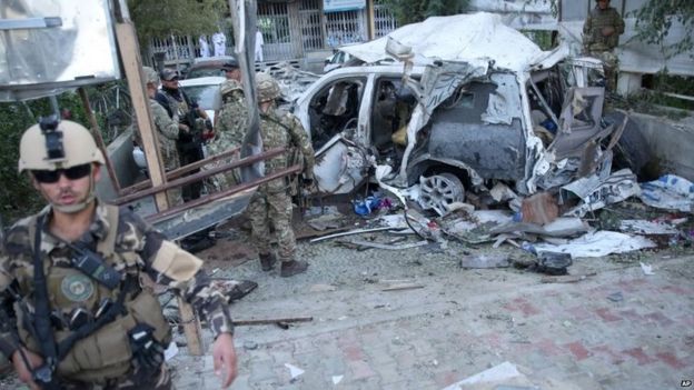 Afghan security forces and British soldiers inspect the site of a suicide attack in the heart of Kabul (22 August 2015)