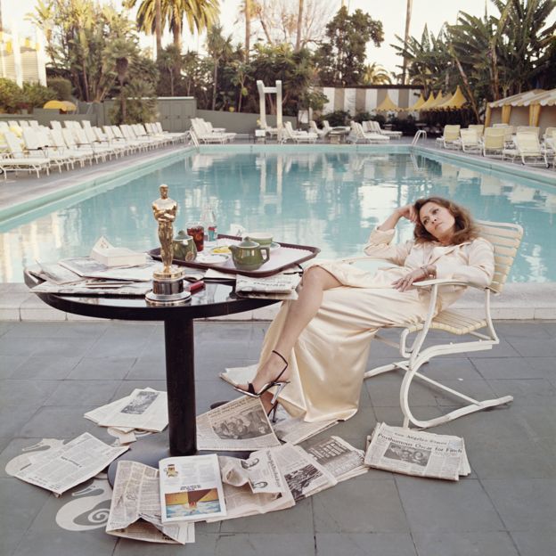 American actress Faye Dunaway by a pool with newspapers at the Beverley Hills Hotel in 1977