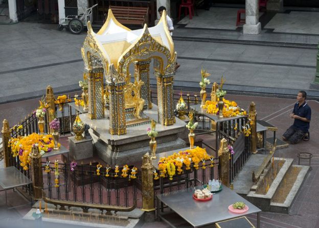 A visitor makes an offering for Phra Phrom, the Thai interpretation of the Hindu god Brahma at the Erawan Shrine, the scene of the 17 August bombing, in Bangkok, Wednesday, 9 September 2015.