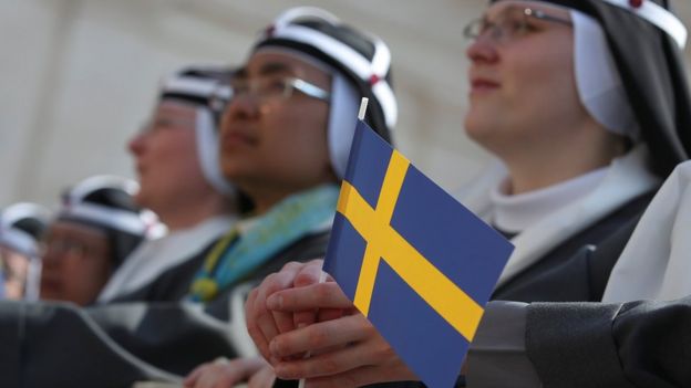A nun holds a Swedish flag as she attends as Pope Francis arrives to lead the mass for the canonization of Swedish nun Sister Maria Elisabeth Hesselblad - 5 June 2016