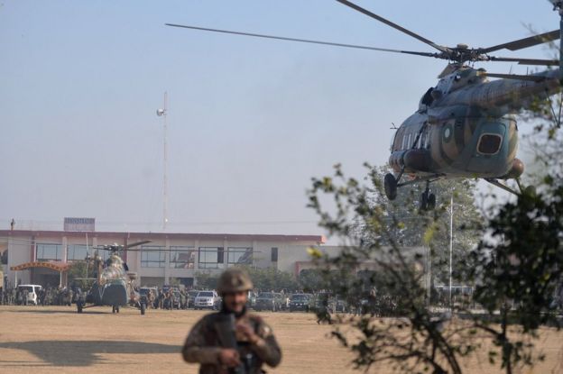 An army helicopter (R) carrying Pakistani army chief Raheel Sharif arrives at Bacha Khan University following the attack by militants in Charsadda, 20 January