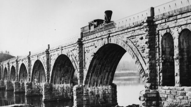 1859: A steam train on the Columbia Railway Bridge, crossing the Schuylkill River in Pennsylvania.