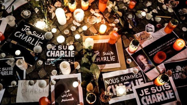 Papers with 'I am Charlie' in various languages displayed are left near candles at a vigil in front of the French Embassy following the terrorist attack in Paris on 7 January 2015 in Berlin, Germany