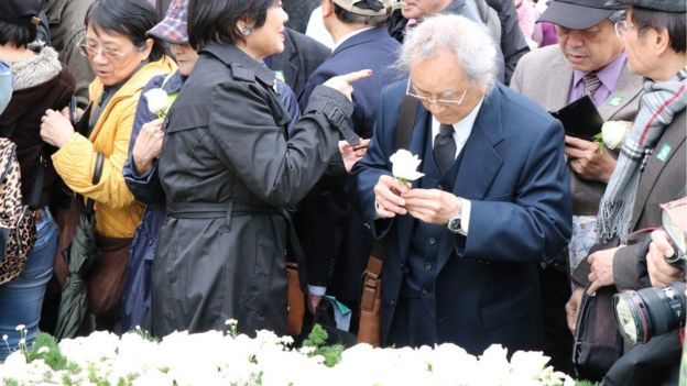 中枢纪念仪式结束后，许多民众排队献花，还有人低头啜泣。