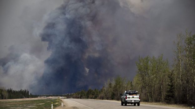 A truck drives into the smoke outside Fort McMurray