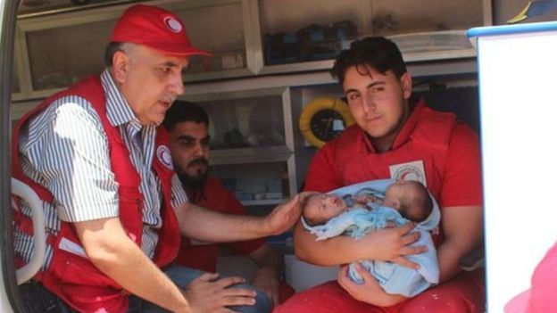 Red Crescent workers hold the babies