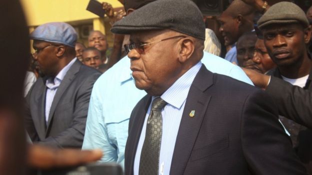 Opposition leader walking with a crowd surrounding him.