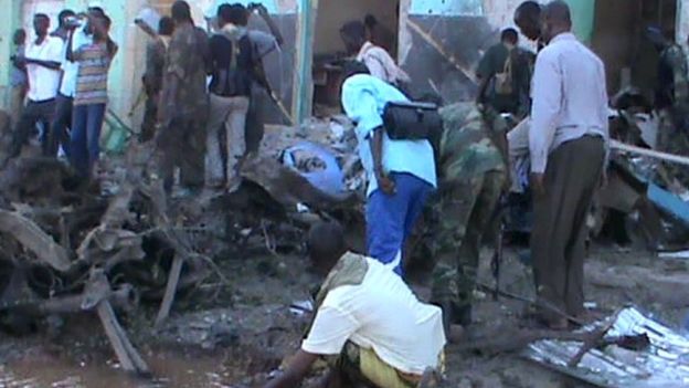 People and soldiers search in the rubble of a destroyed building on 28 February, 2016 in Baidoa