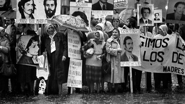 Madres con pañuelos blancos en la cabeza llevan carteles con las fotos de hombres y mujeres y mensajes que exigen el hallazgo de su paradero.