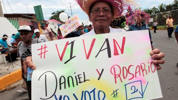 Un hombre con un letrero de apoyo a Daniel Ortega y Rosario Murillo.
