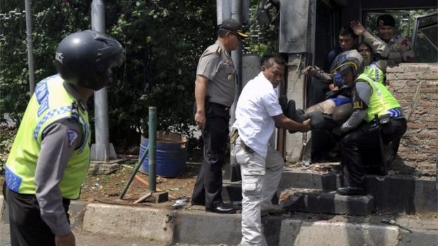 An injured policeman is removed from the Starbucks cafe in Jakarta (14 Jan 2016)