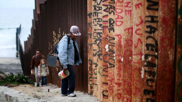 Un hombre frente a la valla que separa a EE.UU. de México en largos tramos de la frontera.