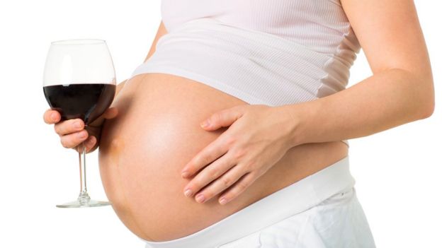 pregnant woman holding a wine glass