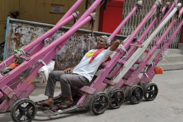 An Indian labourer rests on luggage push carts parked in a market street during a nationwide strike called by 10 major trade unions over wages and economic reforms, in Secunderabad, the twin city of Hyderabad on September 2, 2016.