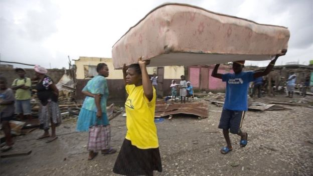 Residentes de Les Cayes trasladan un colchón a un refugio.