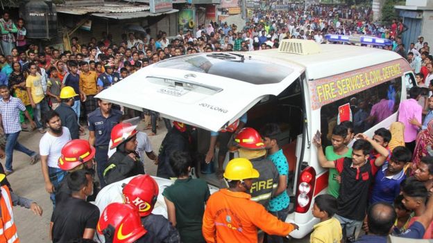 Firefighters carry victims to an ambulance after factory fire in Tongi, Bangladesh, on 10 September 2016