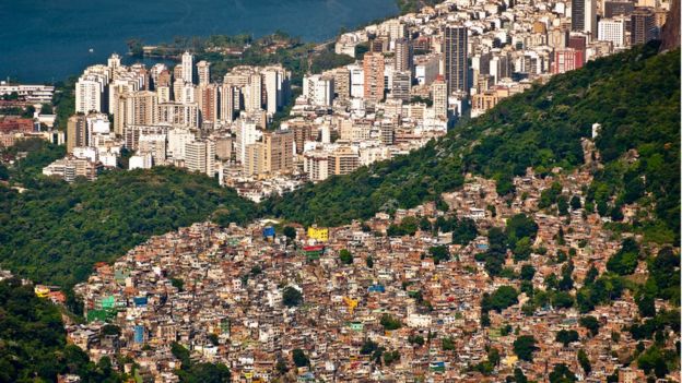 Vista do Rio de Janeiro com favela da Rocinha em primeiro plano e bairro de classe média ao fundo