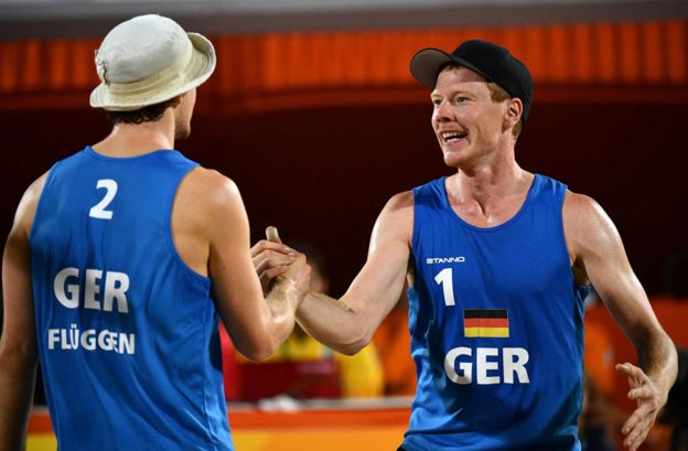 Germany's Lars Fluggen and Markus Bockermann celebrate after winning a point during the men's beach volleyball qualifying match between the Netherlands and Germany at the Beach Volley Arena in Rio de Janeiro on August 8, 2016