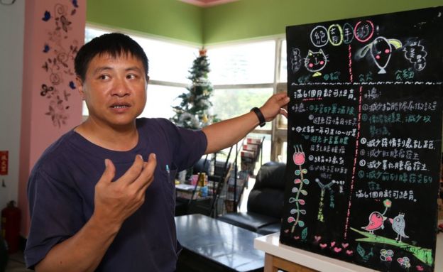 A man stands in front of a board in the shelter