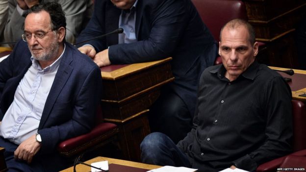 Former Greek Finance Minister Yianis Varoufakis (R) sits next to former Greek Energy Minister Panagiotis Lafazanis (L) during the vote at the Greek parliament in Athens early on July 23, 2015