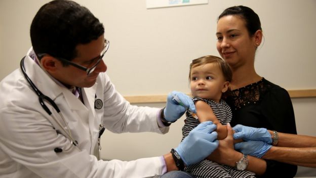 Médico vacuna a niña