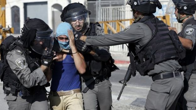 Israeli police arrest a Palestinian during clashes at a refugee camp