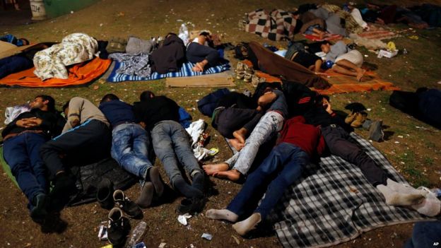 Migrants sleep at a park where hundreds of migrants are temporarily residing in Belgrade, Serbia, early Tuesday, Sept. 1, 2015