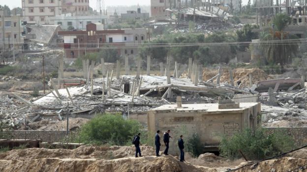 Palestinian men in Gaza look at a house destroyed by Egyptian security forces in the Egyptian border town of Rafah (2 November 2014)