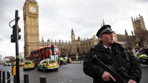 An armed police officer stands guard near Westminster Bridge