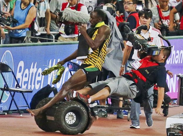 Usain Bolt of Jamaica is hit by a cameraman on a Segway as he celebrates after winning the men's 200 metres final at the 15th IAAF World Championships at the National Stadium in Beijing, China, 27 August 2015.