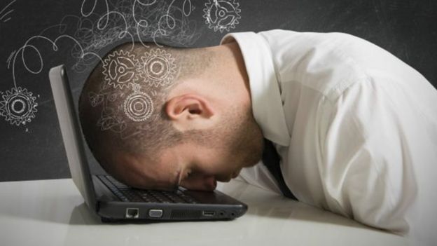 Hombre durmiendo sobre el teclado del computador.