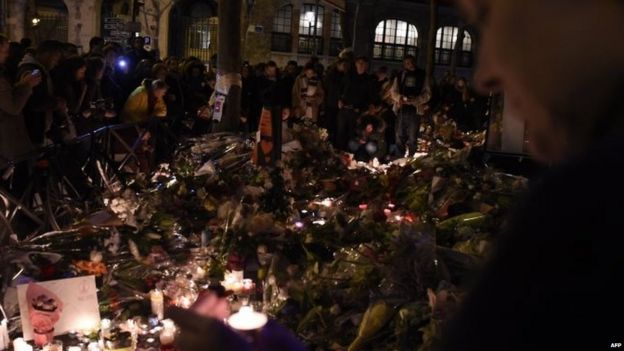 People gather at a makeshift memorial site on November 15, 2015, outside the La Belle Equipe cafe, rue de Charonne,