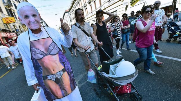 Protesta callejera a favor del matrimonio igualitario, con una imagen de un cuerpo en bikini con una máscara del papa Francisco en la cara.