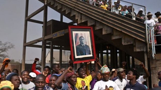 People carry a portrait of Robert Mugabe at Harare's stadium. Photo: 12 September 2019
