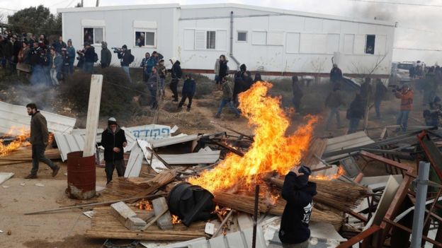 Protesters set furniture on fire during an operation to evacuate the unauthorised settlement outpost of Amona in the occupied West Bank (1 February 2017)