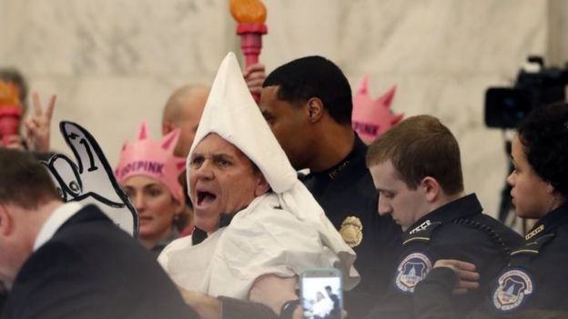 A protester is escorted out of the Senate Judiciary Committee confirmation hearing for Senator Jeff Sessions as attorney general.