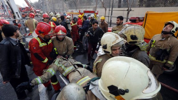 A wounded fireman is carried from the collapsed Plasco building in Tehran, Iran (19 January 2017)