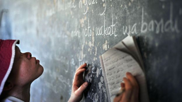 Because of their low vision, children with albinism struggle to read the blackboard in class