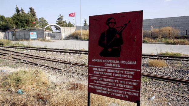 A Turkish military warning sign, with the closed Karkamis border gate in the background