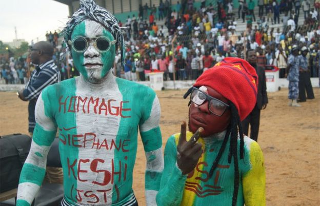 Man covered in bodypaint in Nigeria's green and white colours, with the message hommage to Stephen Keshi, stands in stadium 20 June 2016