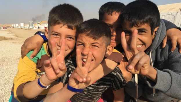 أطفال نازحون عراقيون يرفعون إشارة السلام