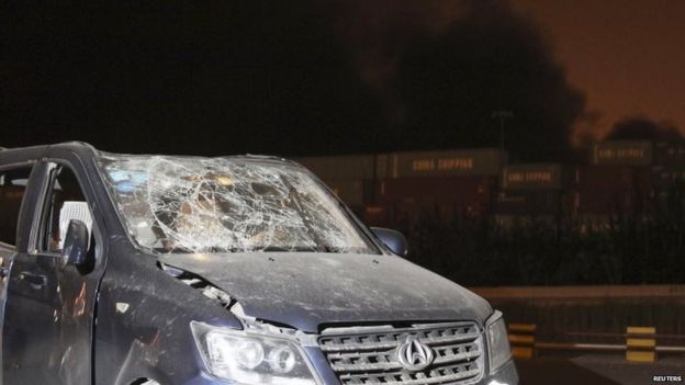 A damaged vehicle is seen near the site of the blasts at Binhai district in Tianjin