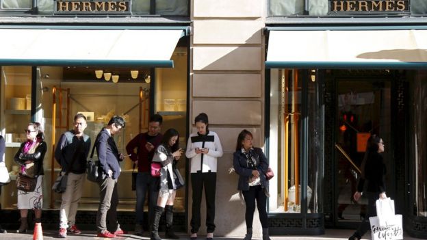 Customers queue up as they wait the opening of the main shop of French luxury group Hermes in Paris, France, in this September 23, 2015 file photo