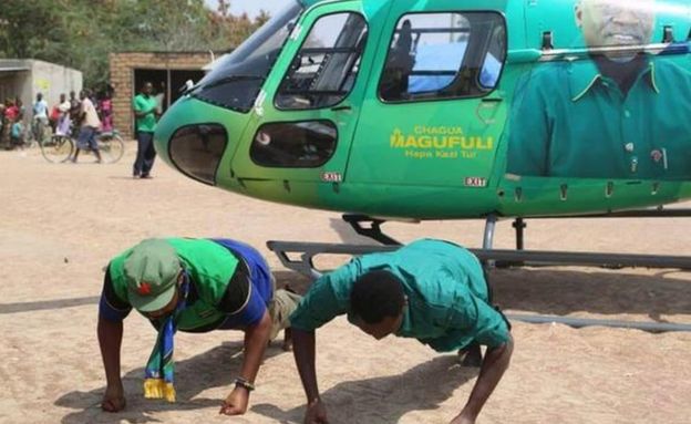 CCM politicians doing press-ups in front of a helicopter
