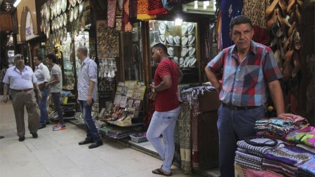 Store clerks wait for customers outside their businesses at Cairo